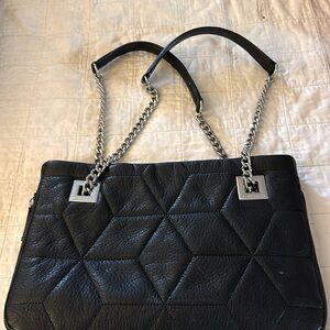Black quilted Calvin Klein purse with silver chain and leather straps.